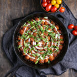 A top-down shot of tater tots, arranged in a cast iron pan.