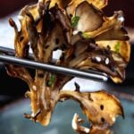 A cooked maitake mushroom with chopsticks.