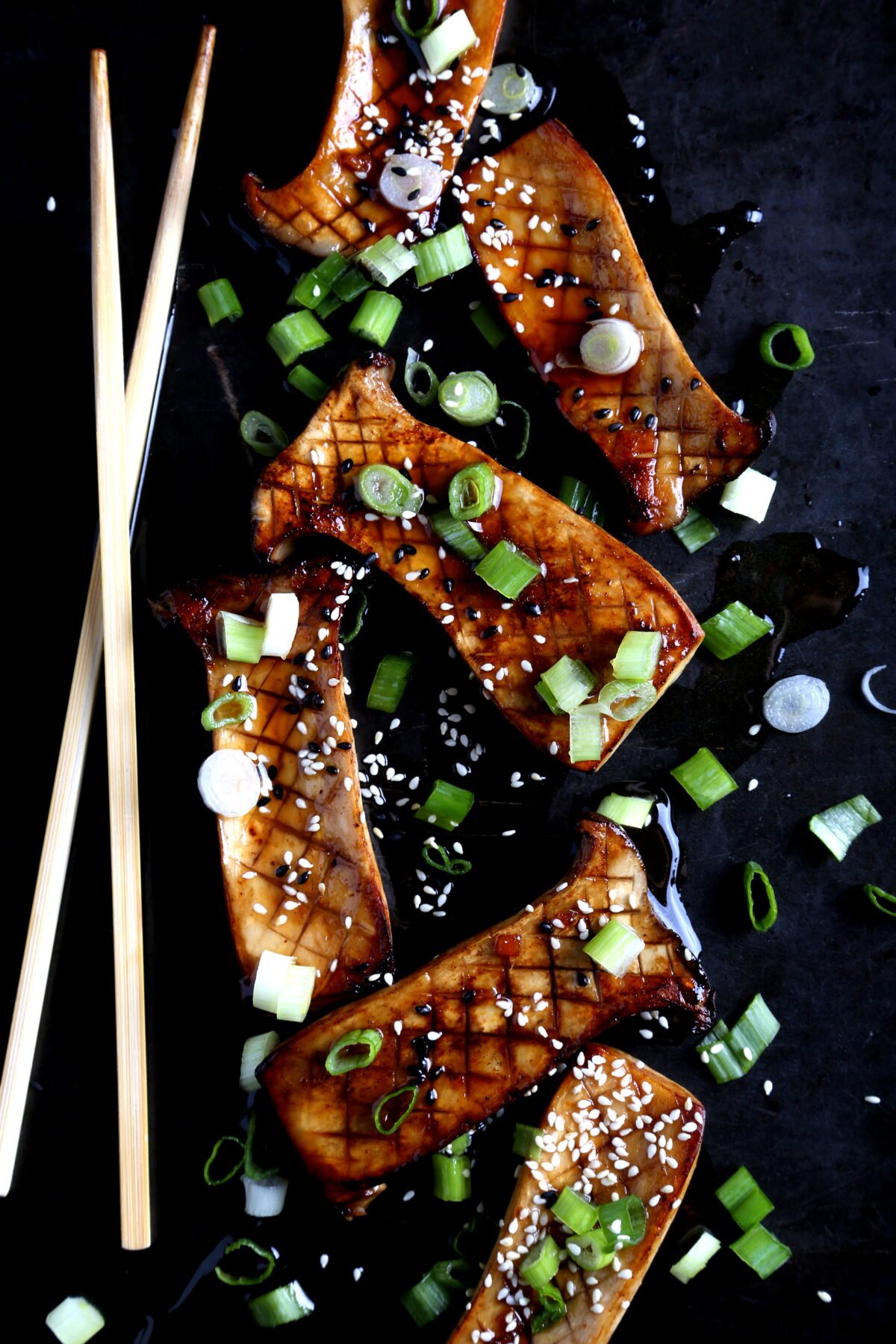 Grilled and scored king oyster mushrooms glazed with teriyaki sauce for a savory finish.