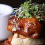 Vegan chicken and waffles with garnish.