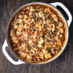 Vegan mapo tofu in a white Dutch oven, highlighting the rich red sauce and tender tofu cubes.
