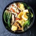 Vegan ramen bowl with sauteed tofu, mushrooms, wilted bok choy, and chilis.