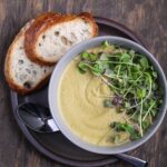 A bowl of vegan split pea soup with bread.